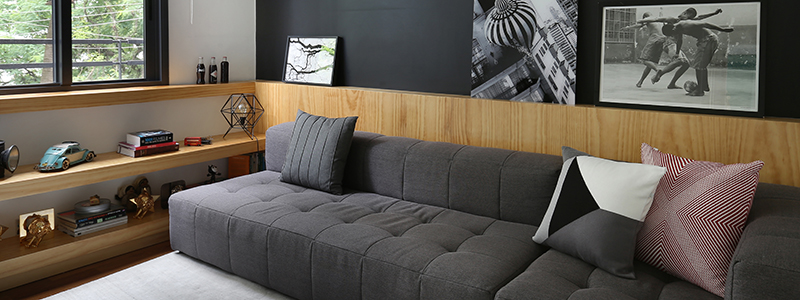 sala de tv com sofá cinza e marcenaria em pinus